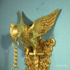 Brass Parrot Wall Hanging – 26 cm | Sitting on Tree Holding Designer Bell | Antique Golden Finish | Handcrafted Decor for Temple, Home & Wall